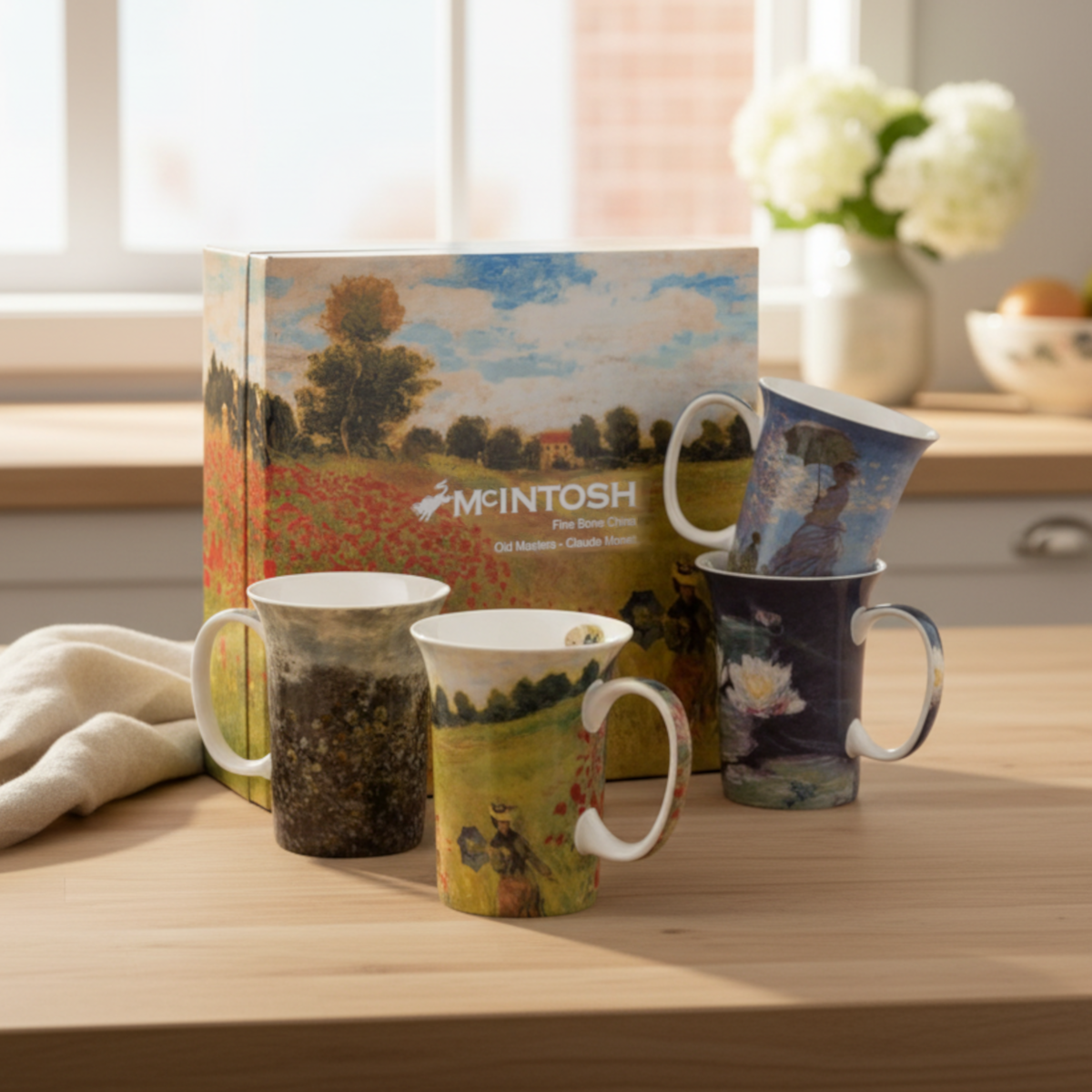 Four fine bone china mugs, each featuring a painting by artist Claude Monet displayed alongside an ornate gift box with a matching print.