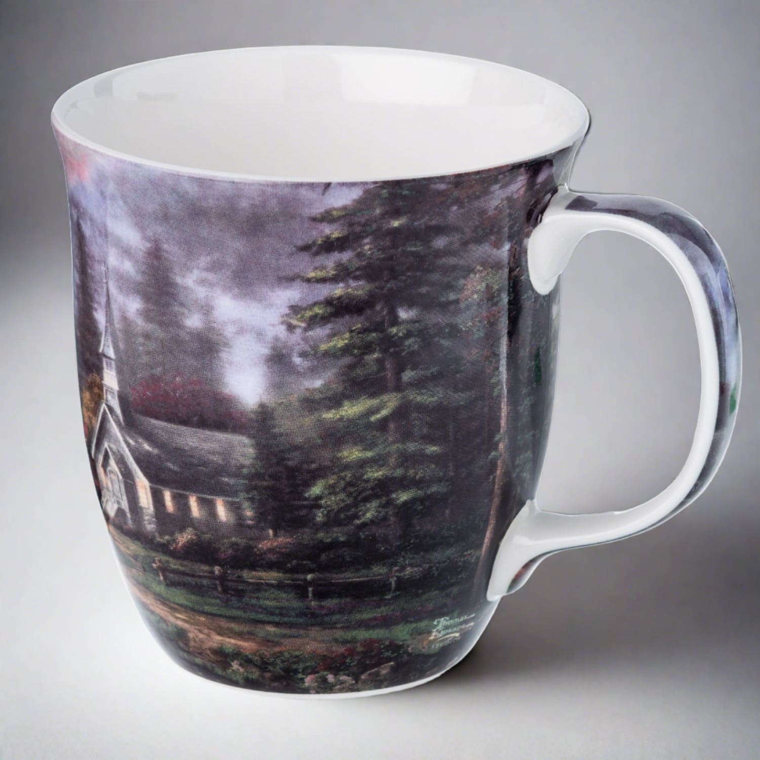 Kinkade Valley Chapel Java Mug, lifestyle image styled on grey background