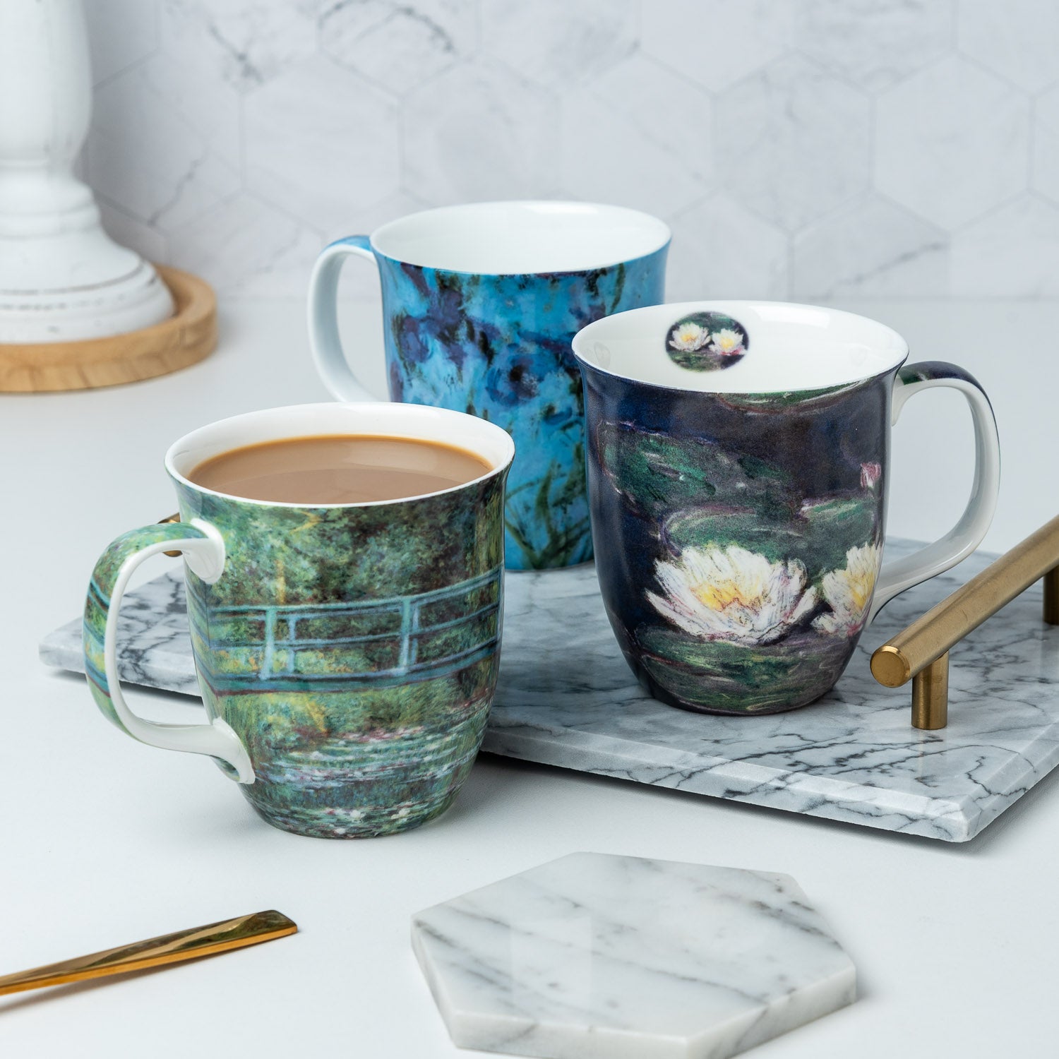 Claude Monet Java mug set featuring Water Lilies, Japanese Bridge, and Lilac Irises Java Mug, lifestyle image styled on a countertop with coffee