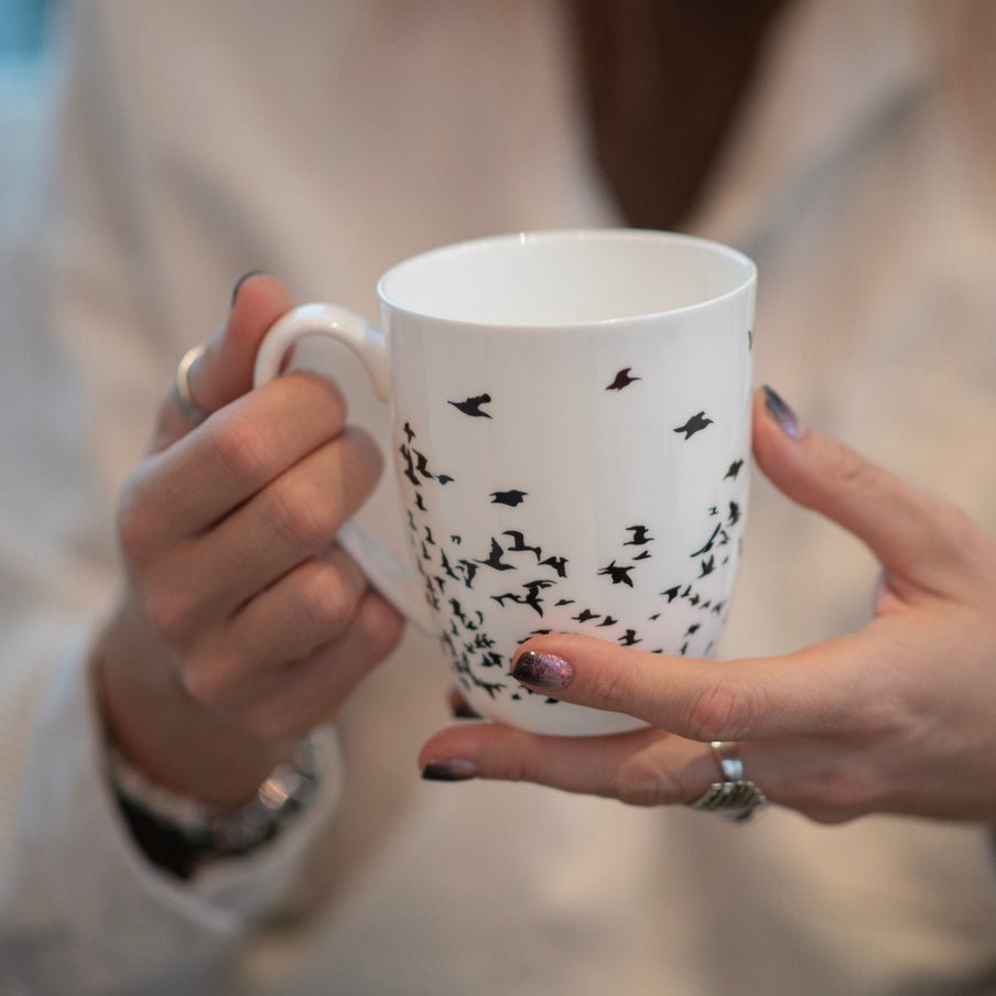 Flock of Birds Silhouette Latte mug held in hand