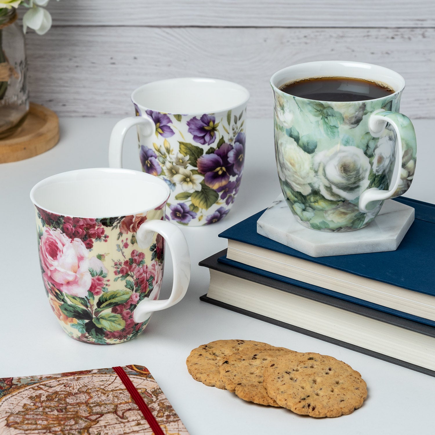 Floral Chintz mug bundle of three featuring Rose Bouquet, Purple Pansies and White Roses, Java Mug, lifestyle image styled on a countertop with coffee
