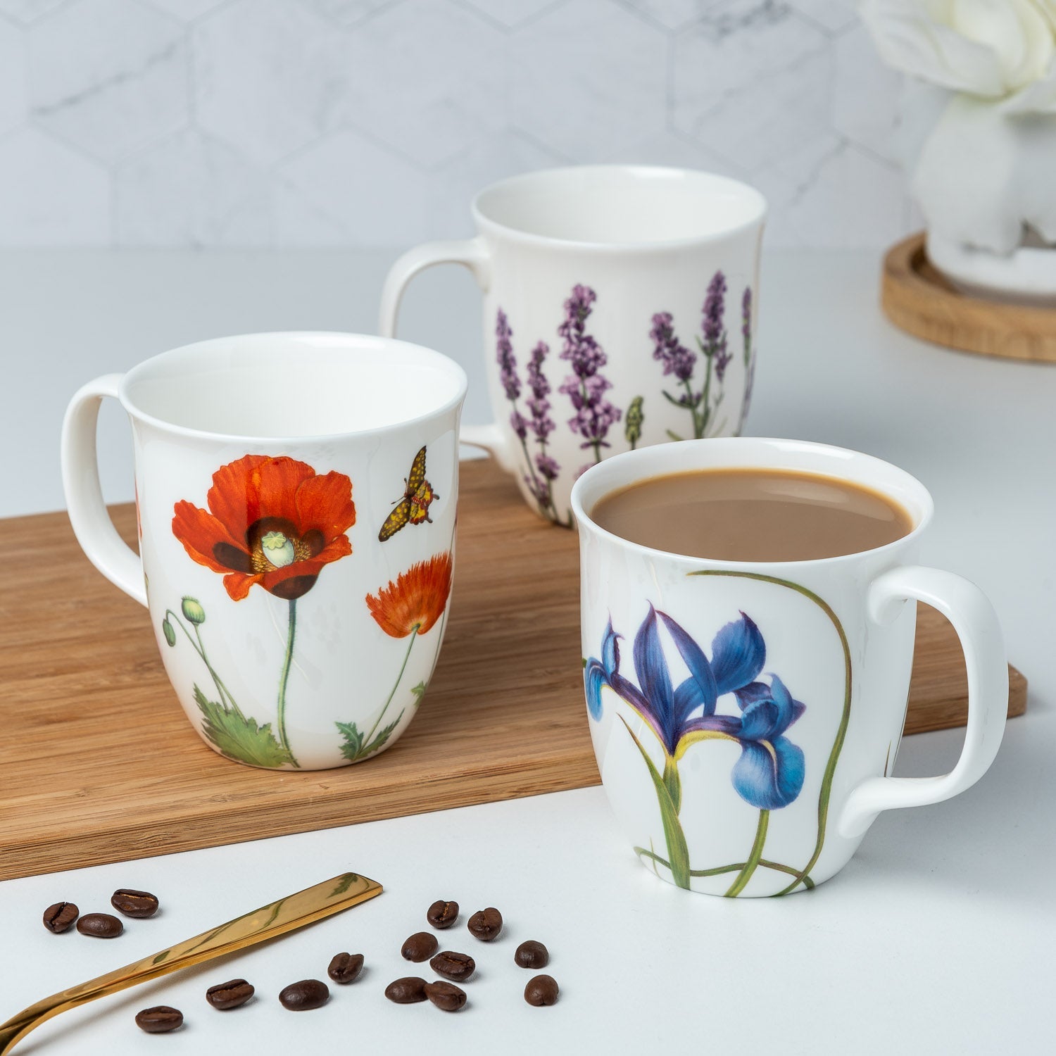 Garden Collection Poppies, Blue Iris, Lavender Java Mugs lifestyle image styled on a countertop with coffee with flowers