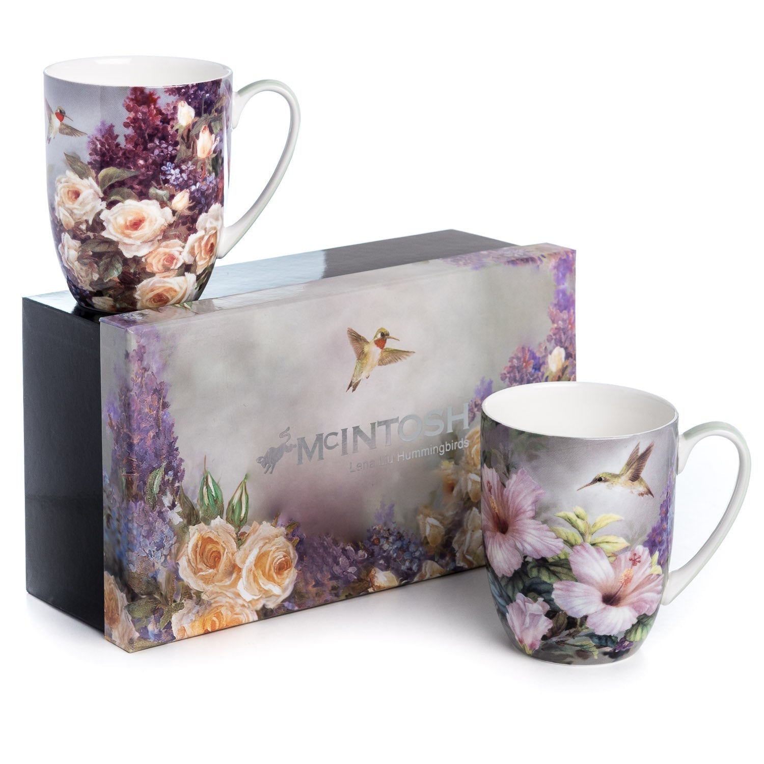 Fine bone china mug set with hummingbirds and floral artwork featuring cream roses, purple lilacs, and pink hibiscus flowers, displayed beside a matching decorative gift box.