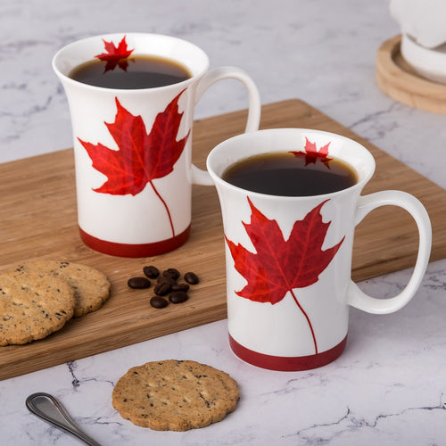 Lifestyle image of two Crest mugs in the Canada design filled with coffee. 