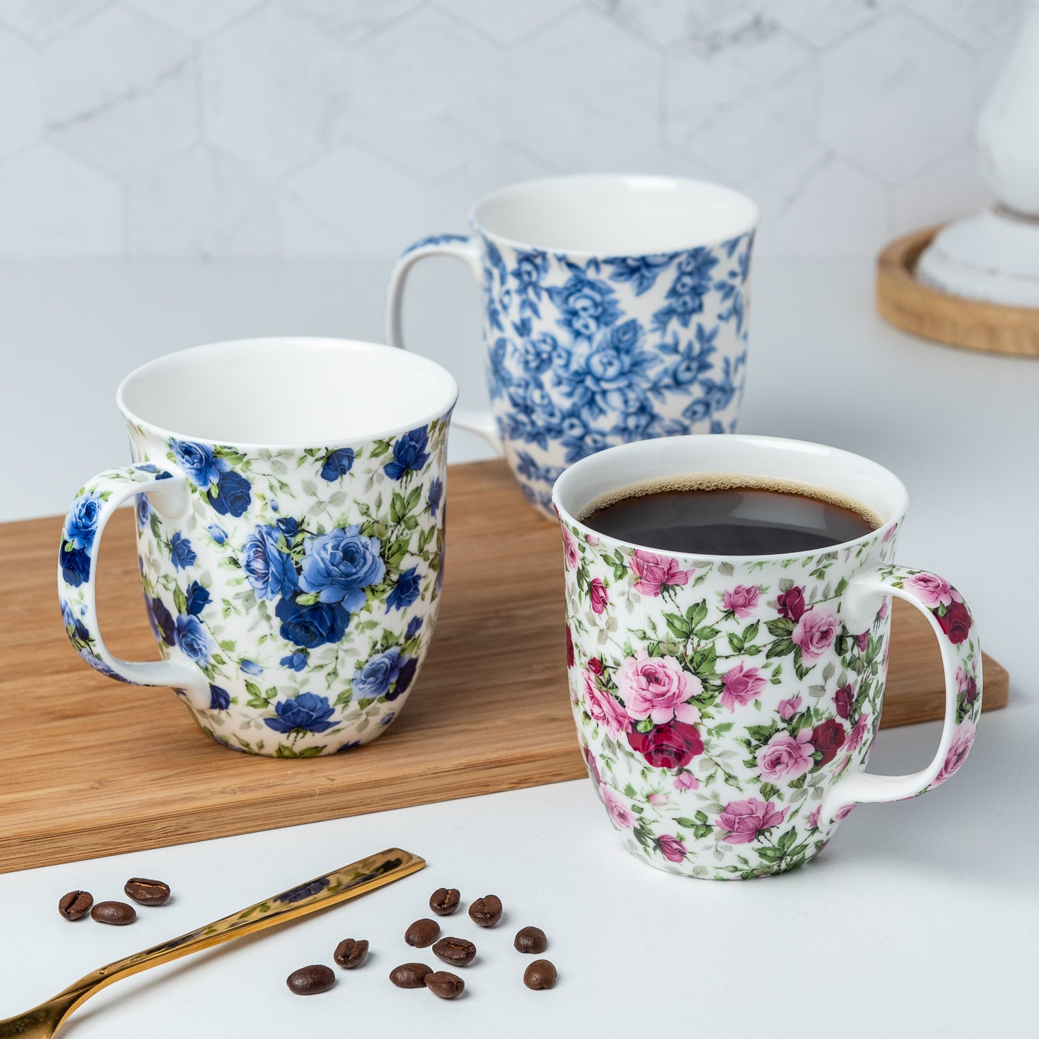 Roses Chintz Java three mug set featuring Red and Pink Roses, Light Blue Roses and Dark Blue Roses Java Mugs, lifestyle image styled on a countertop with coffee