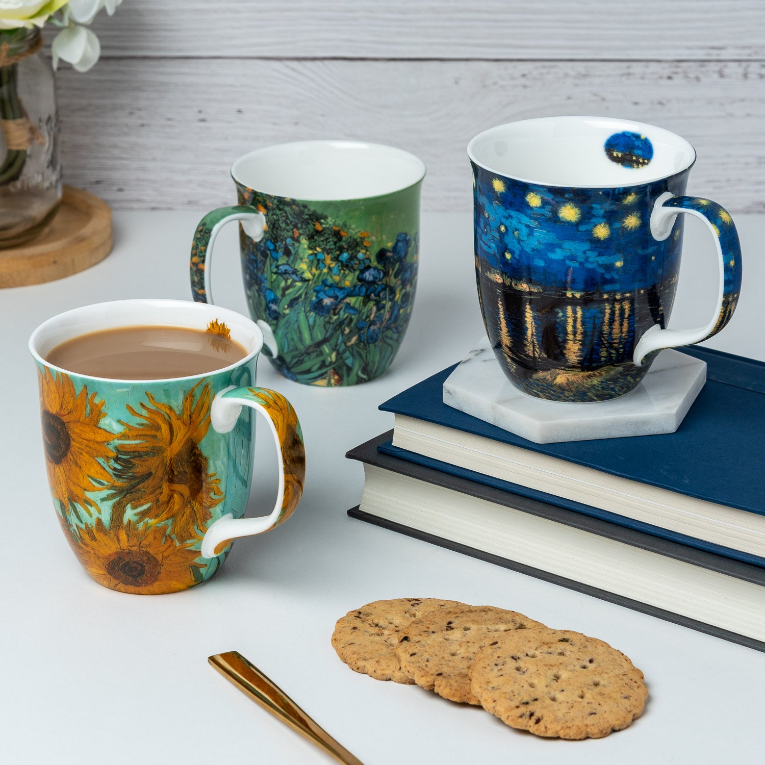 Van Gogh set of three featuring Starry Night over the Rhône Sunflowers and Irises designs Java Mug, lifestyle image styled on a countertop with cappuccino and cookies